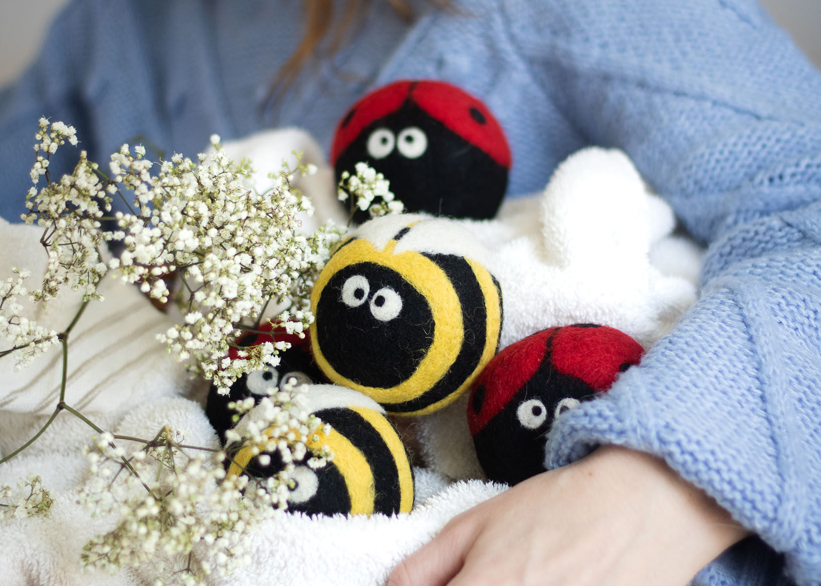 6 white dryer balls with a heart pattern needle felted on them. The hearts are in shades of pink and purple