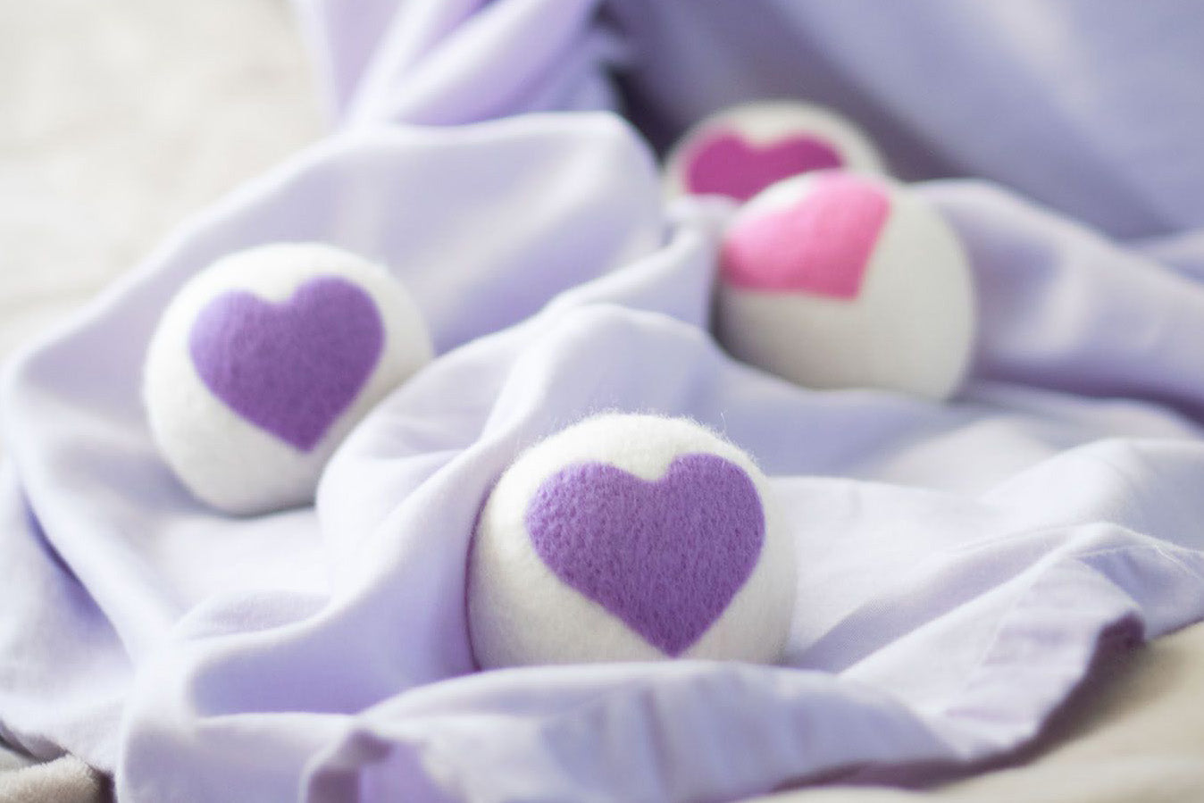 3 heart fresheners (one white, one pink, one purple) on a pink lace fabric